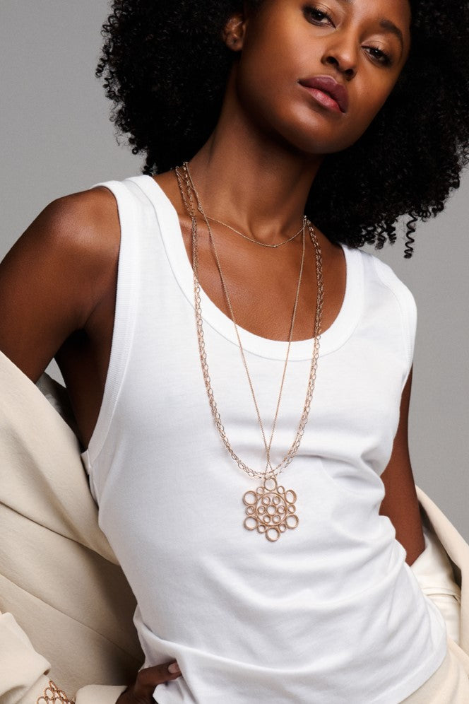 female model wearing a white tank top with necklaces made by O! Jewelry