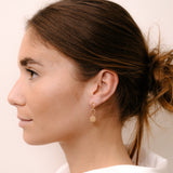 Model wearing circular earring by O! Jewelry on one side